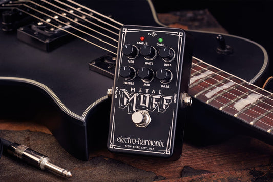 ELECTRO-HARMONIX EHX NANO METAL MUFF  PROMO IMAGE FRONT SIDE VIEW WITH A BLACK GUITAR